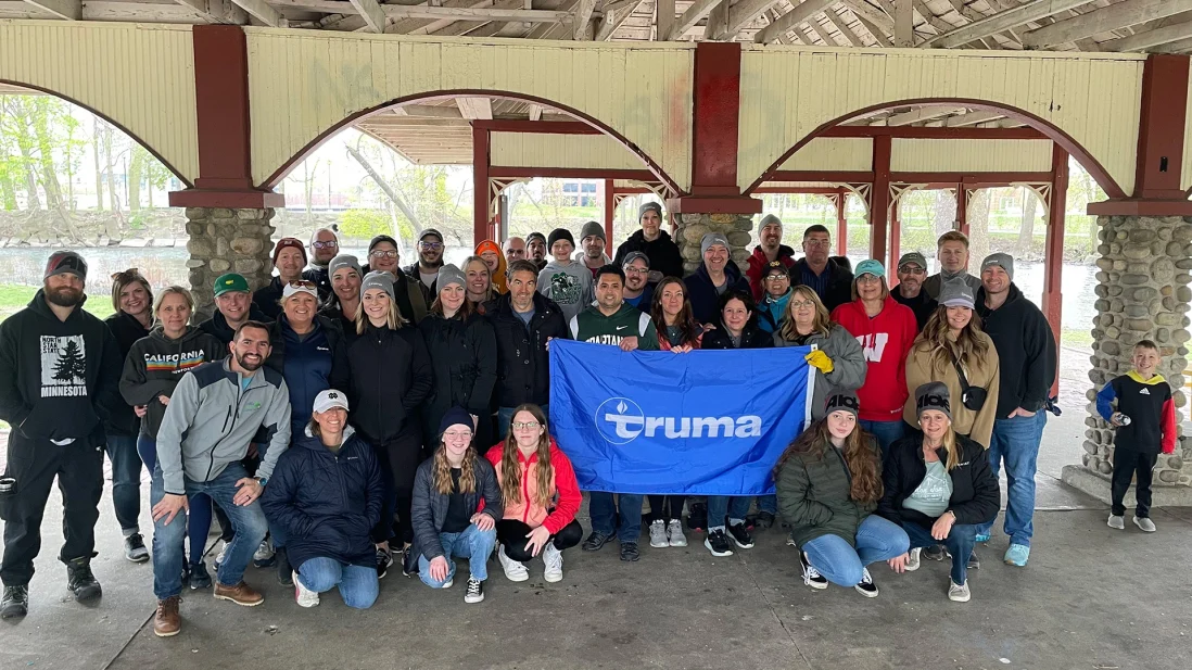 group of volunteers holding truma flag