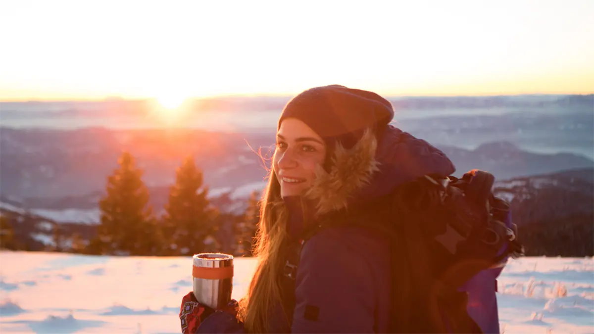 girl with coffee on snowy mountain