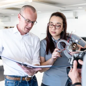 Truma Academy Mitarbeiter erklärt einer Kundin Heiztechnik am Modell